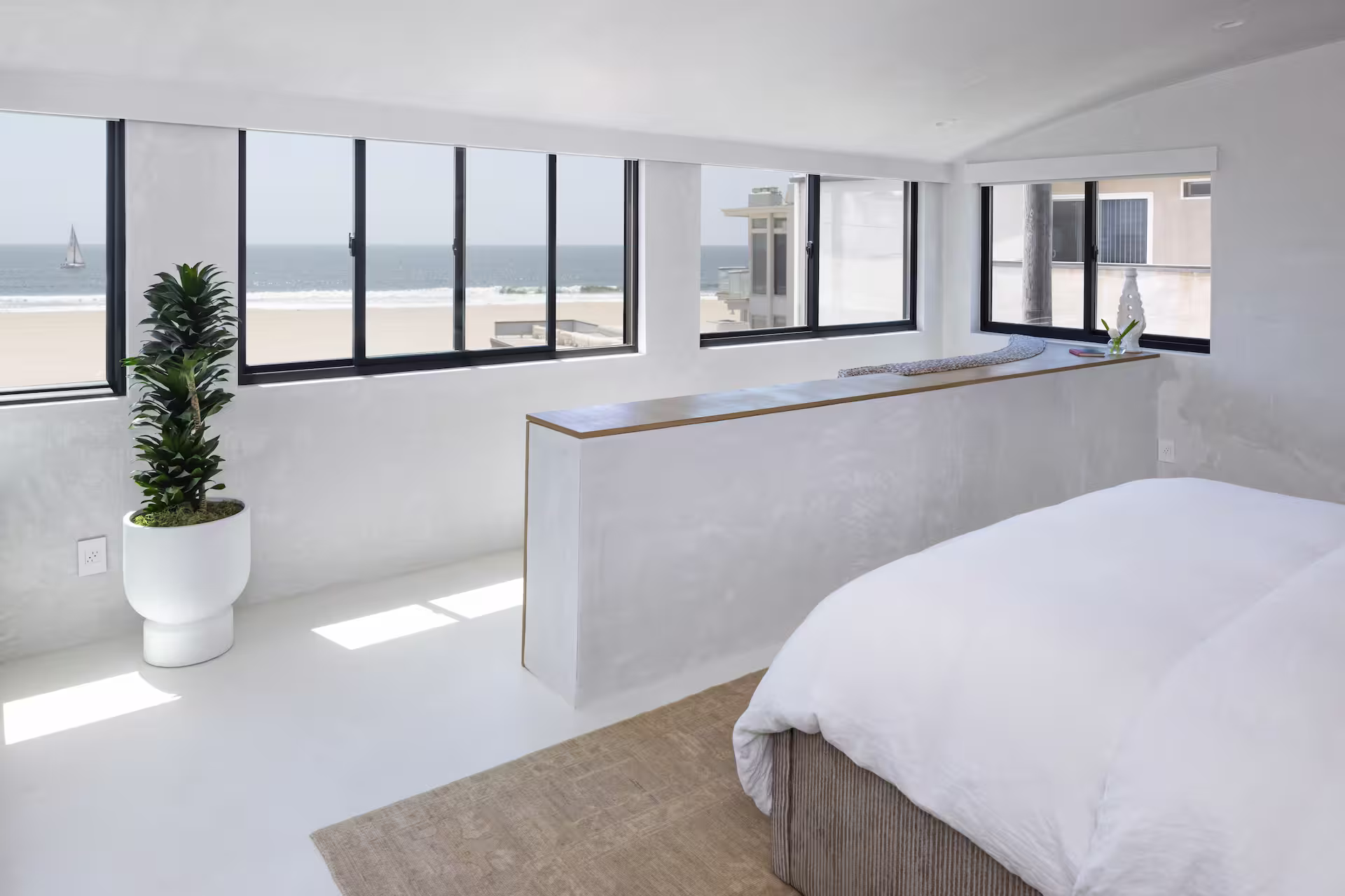 Coastal bedroom with ocean view windows